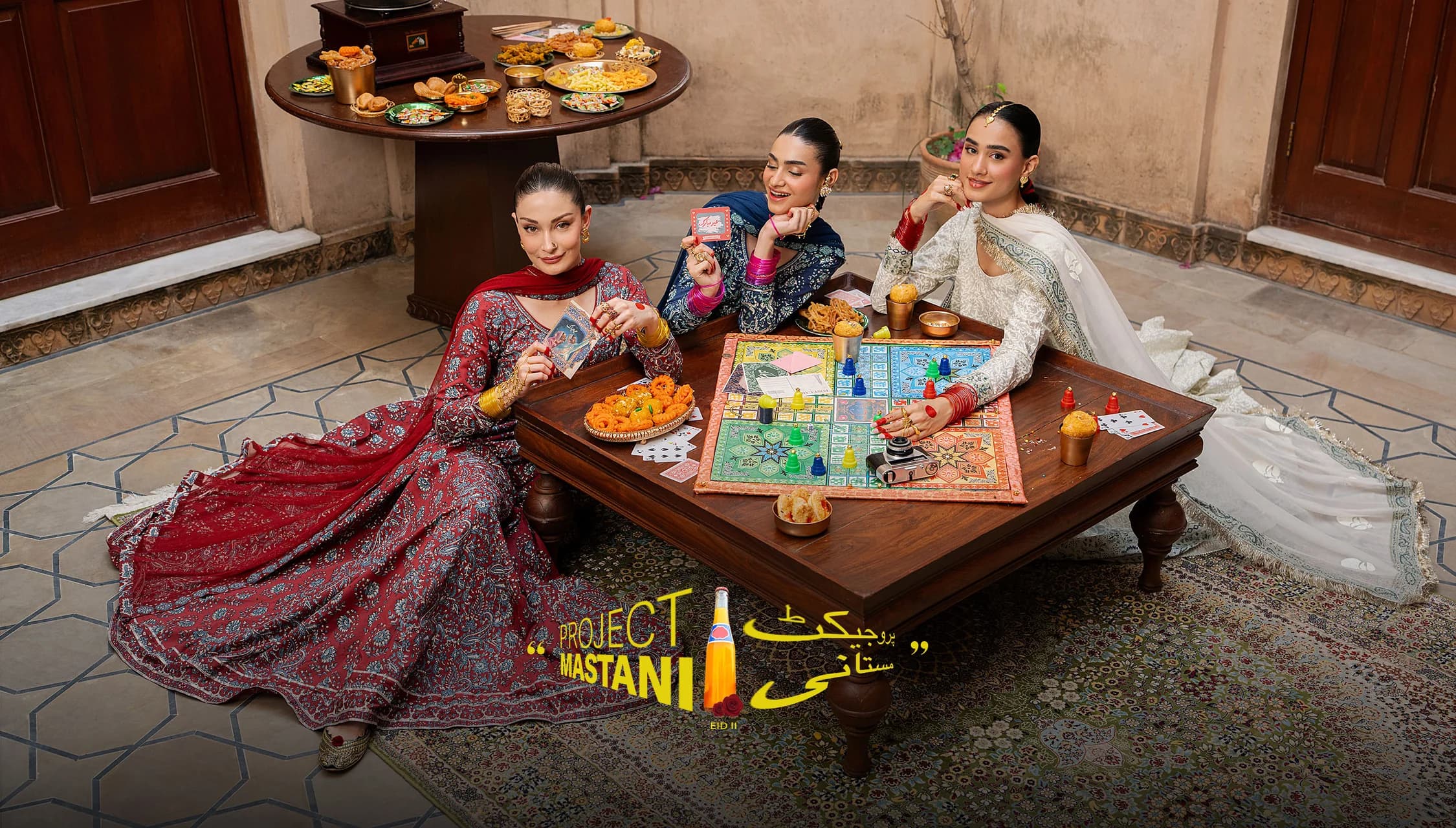 Project Mastani — four models in printed festive wear around a low games table