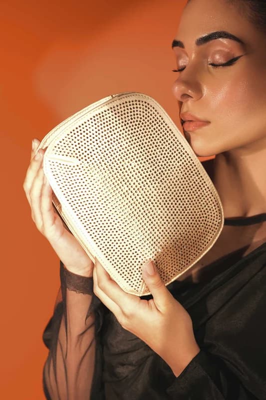 Gold crystal-mesh evening clutch held to the light