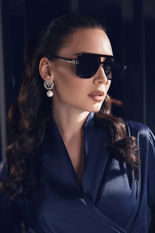 Model in oversized square sunglasses with pearl drop earrings